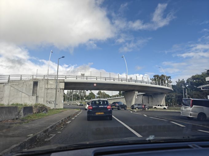 A photo of a bridge from the left passenger seat of a car.