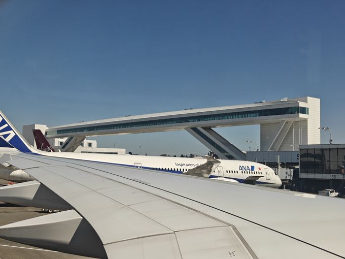 A photo of an air traffic control bridge at an airport, taken from a window seat of a plane overlooking a wing.