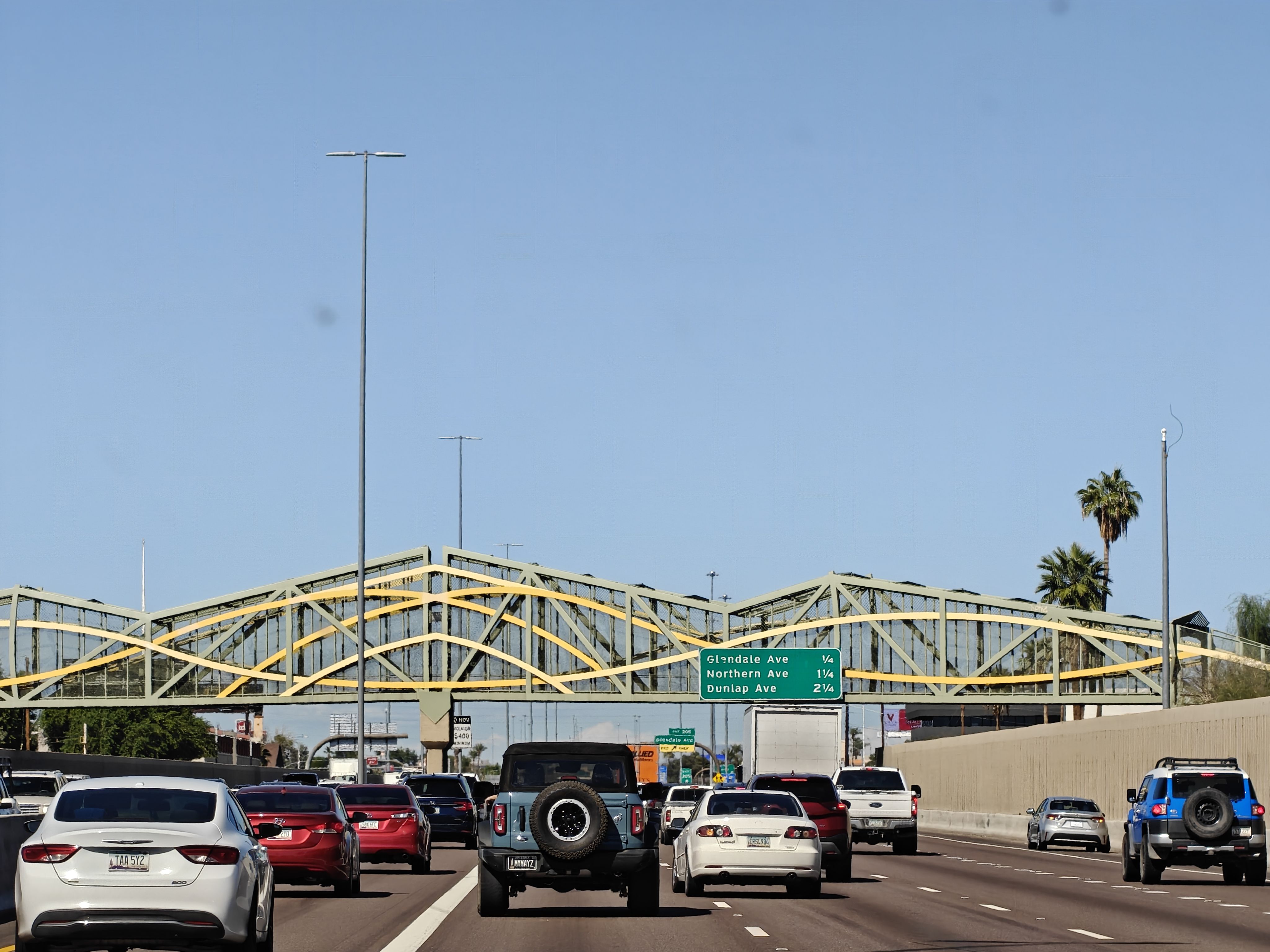 A bridge spans a highway with interesting decorative trusses.